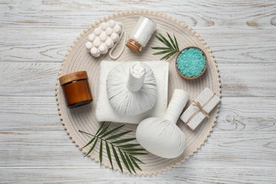 Photo of Composition of herbal bags and spa products on white wooden table, top view