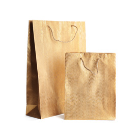 Photo of Golden paper shopping bags isolated on white. Space for design