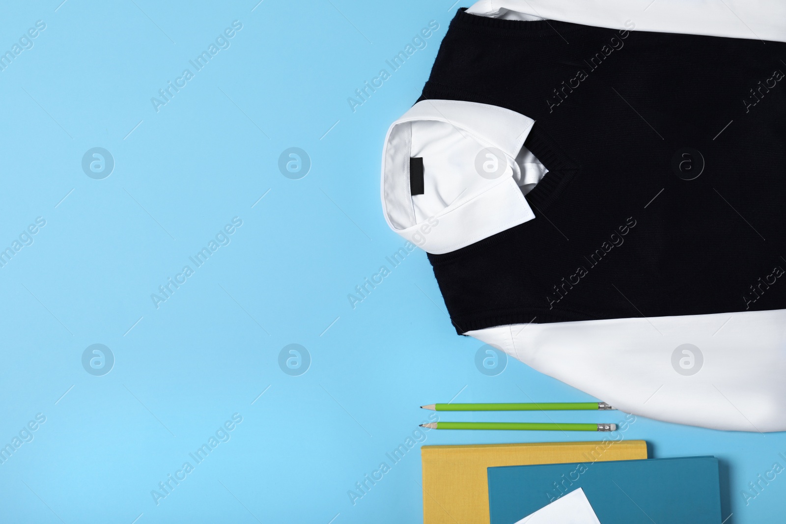 Photo of Flat lay composition with school uniform on blue background. Space for text