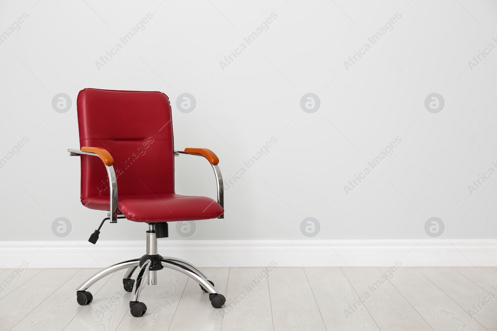 Photo of Comfortable office chair near light wall indoors. Space for text