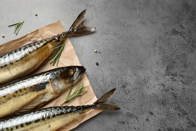 Photo of Tasty smoked fish on grey table, space for text