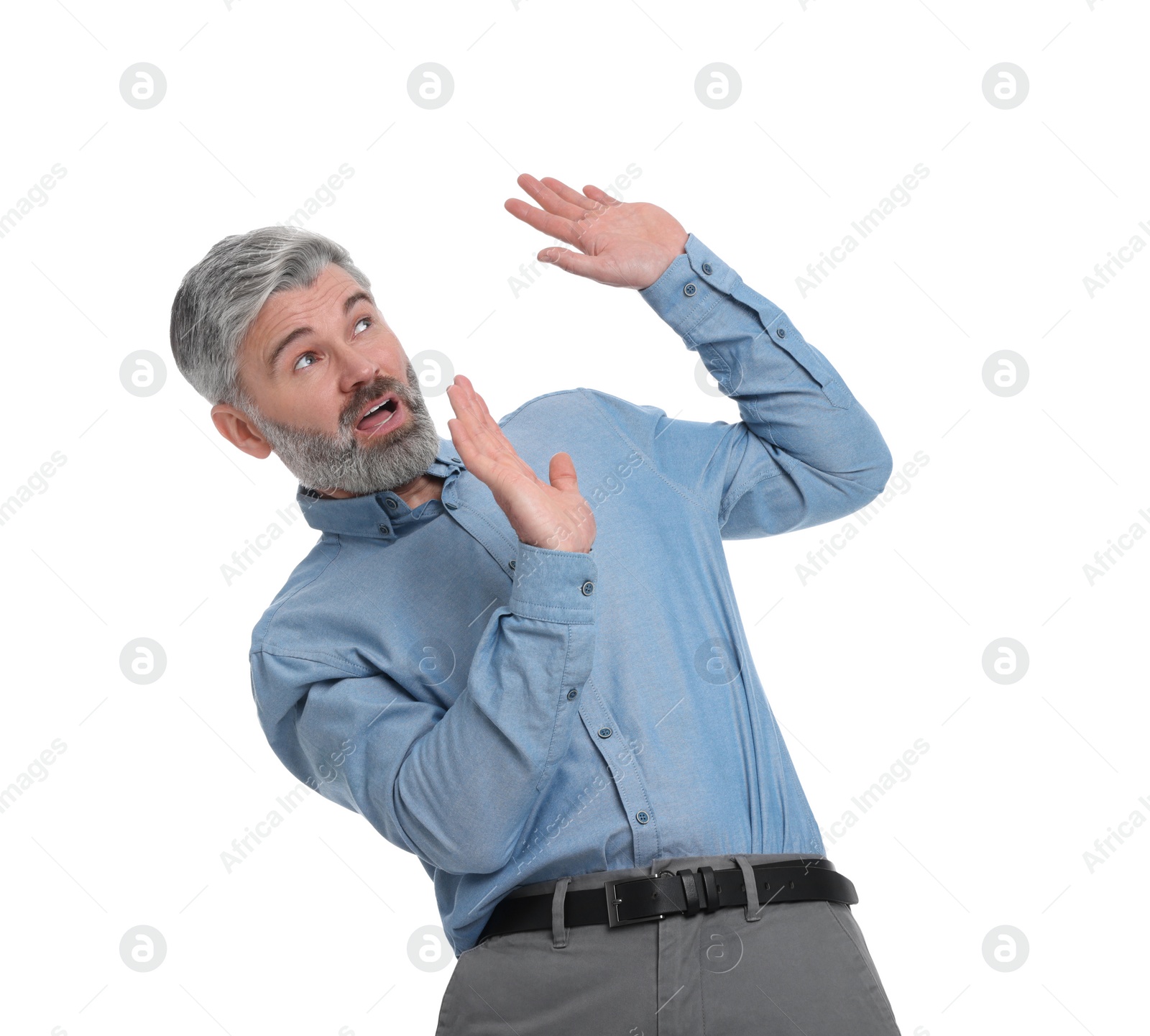 Photo of Mature businessman in stylish clothes avoiding something on white background