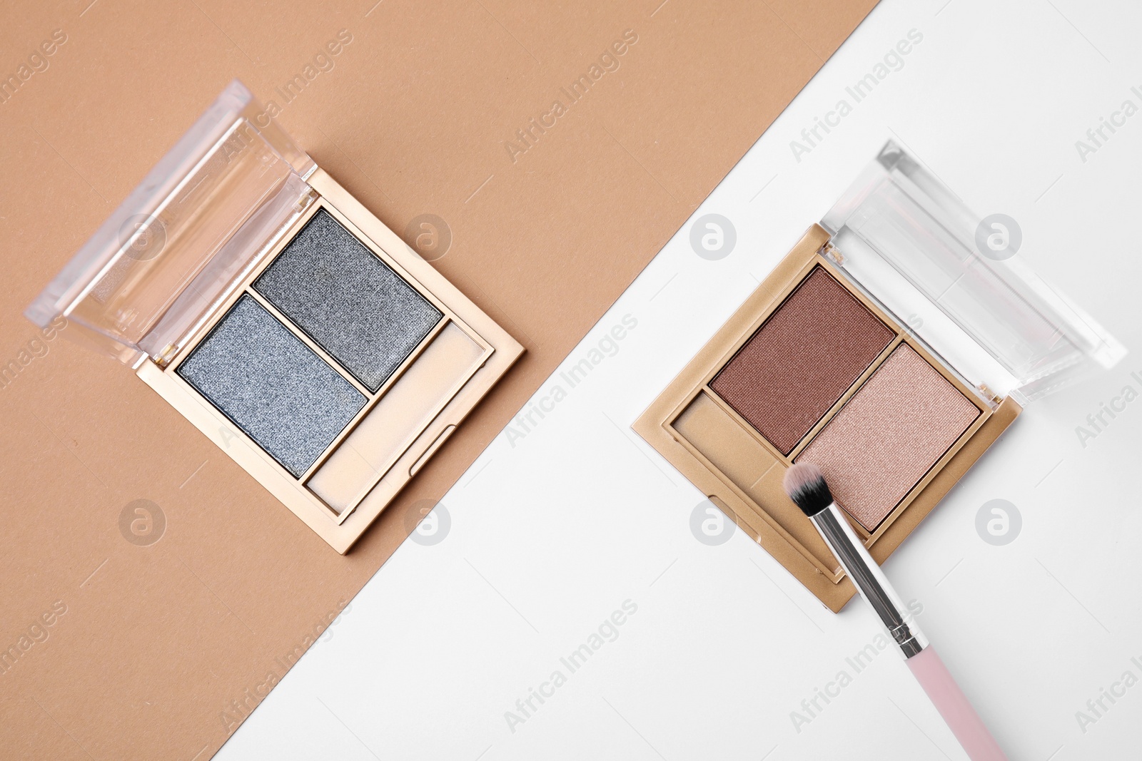 Photo of Eye shadow palettes and professional makeup brush on colorful background, flat lay