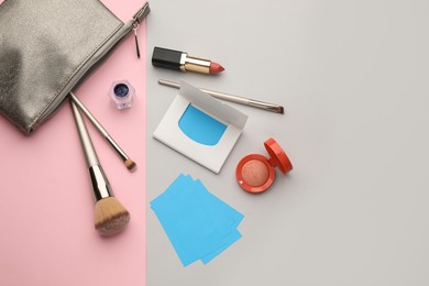 Photo of Flat lay composition with facial oil blotting tissues and makeup products on color background, space for text. Mattifying wipes