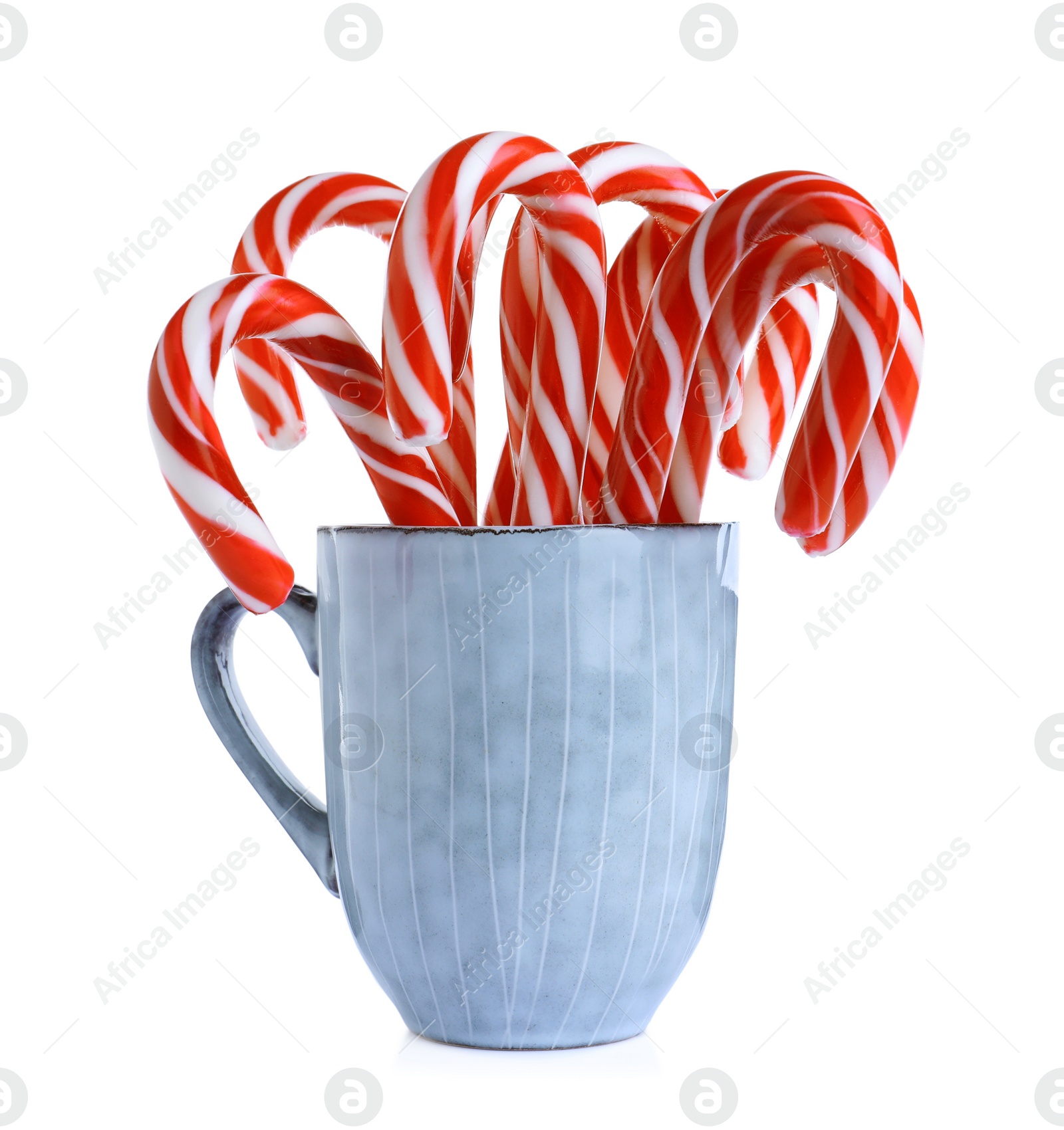 Photo of Grey cup with sweet Christmas candy canes isolated on white