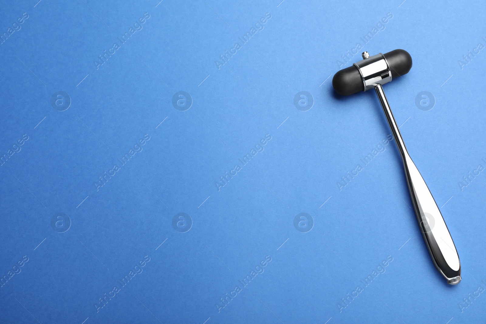 Photo of Reflex hammer on blue background, top view with space for text. Nervous system diagnostic