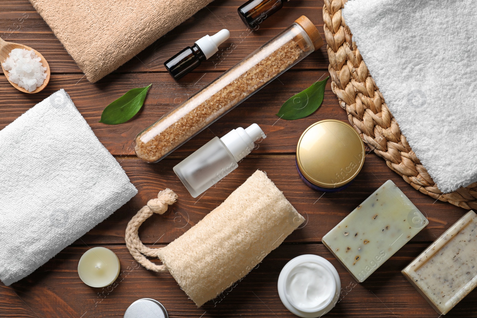 Photo of Flat lay composition with spa cosmetics and towels on wooden background