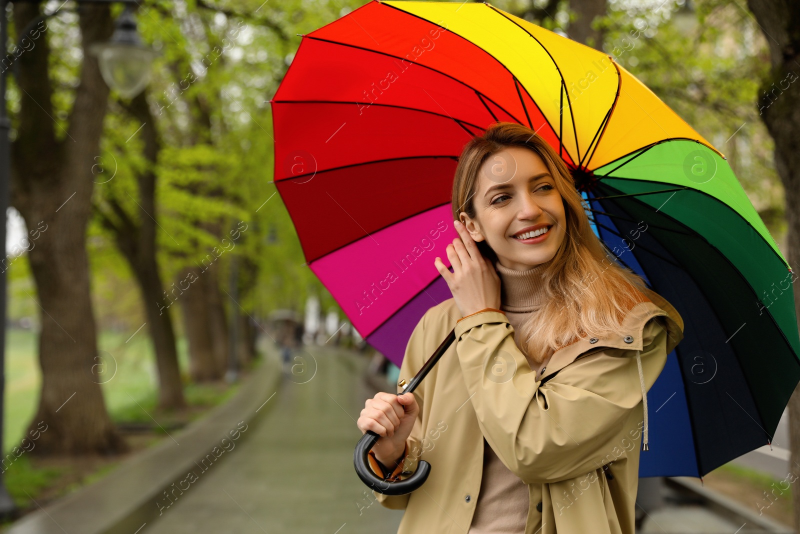 Photo of Young woman with umbrella in park on spring day