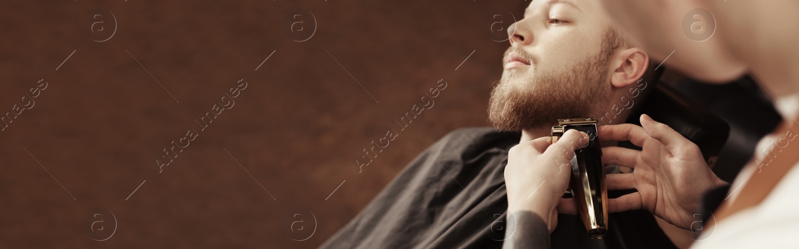 Image of Professional hairdresser working with bearded client in barbershop, space for text. Banner design