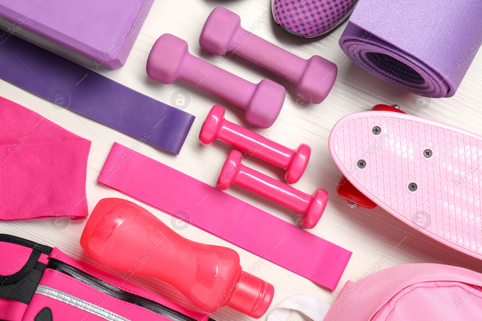 Photo of Different sports equipment on white wooden table, flat lay