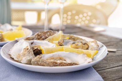 Photo of Fresh oysters with cut juicy lemon served on table