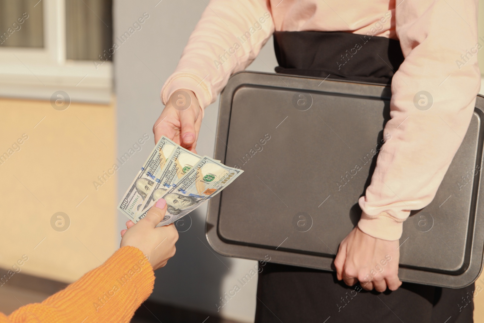 Photo of Woman paying for order to waitress at outdoor cafe, closeup. Leave tip