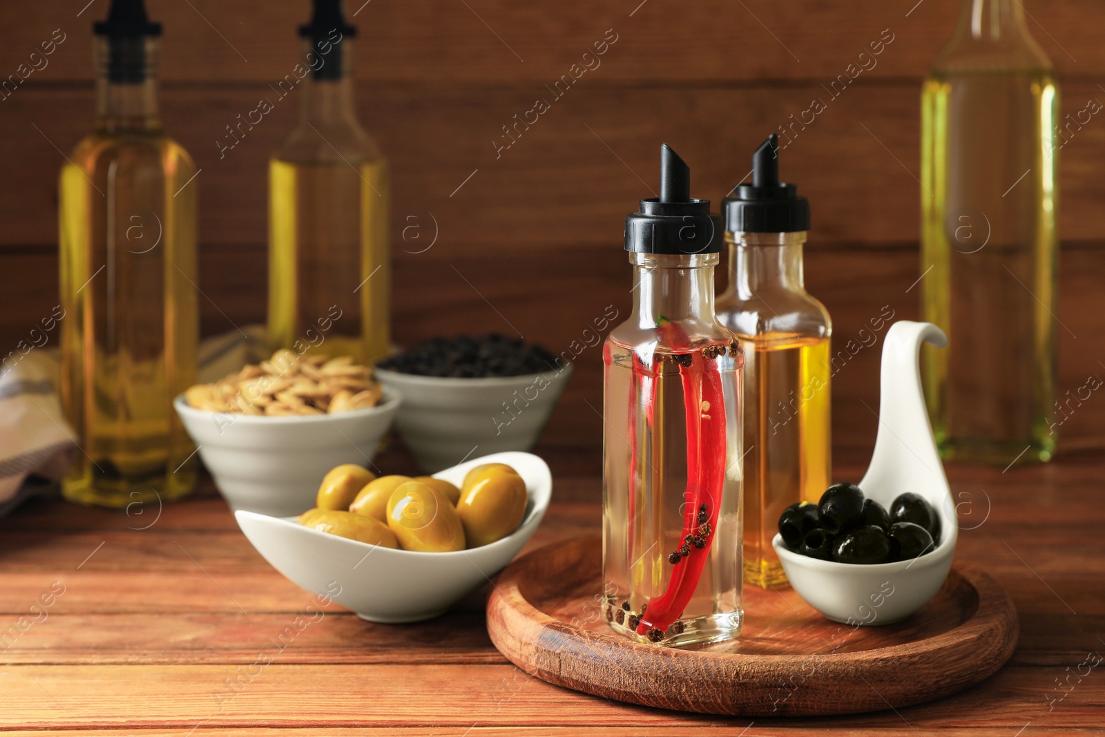 Photo of Different cooking oils and ingredients on wooden table