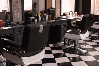 Photo of Stylish monochrome interior of modern barbershop. Equipped workplace