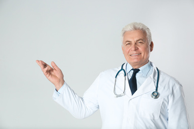 Photo of Portrait of senior doctor against light background. Medical service