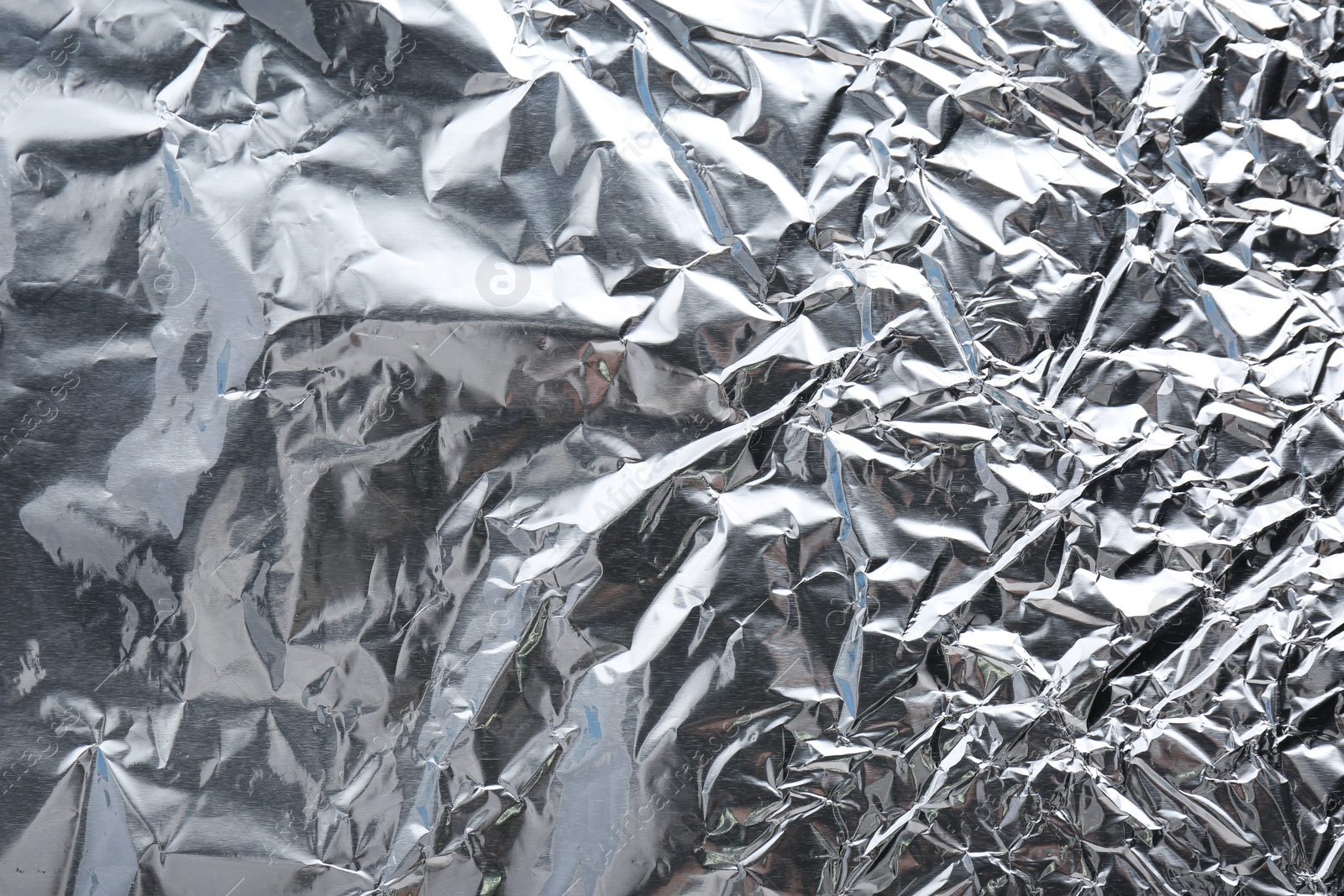 Photo of Crumpled silver foil as background, closeup view