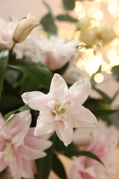 Photo of Bouquet of beautiful lily flowers against blurred lights, closeup