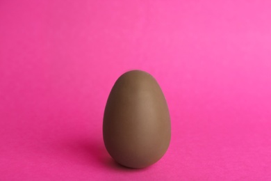 One sweet chocolate egg on pink background