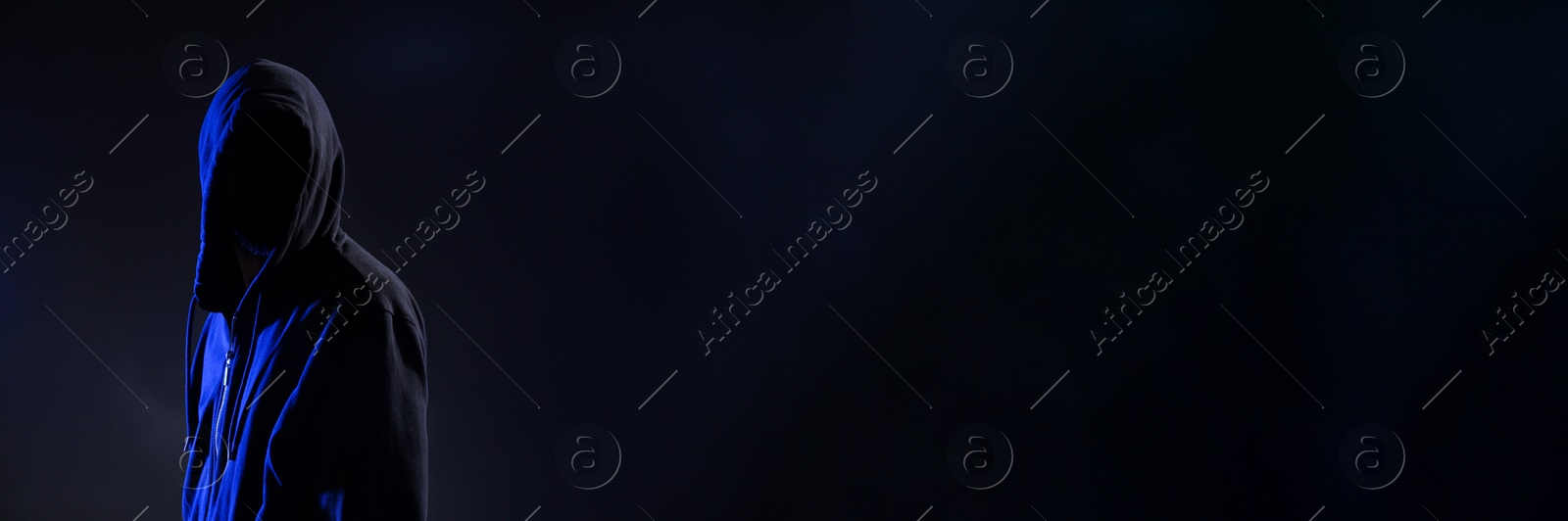Image of Anonymous man in hood on black background, space for text. Banner design