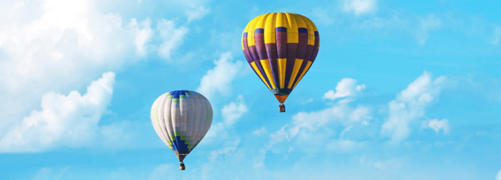 Hot air balloons in blue sky with clouds. Banner design 