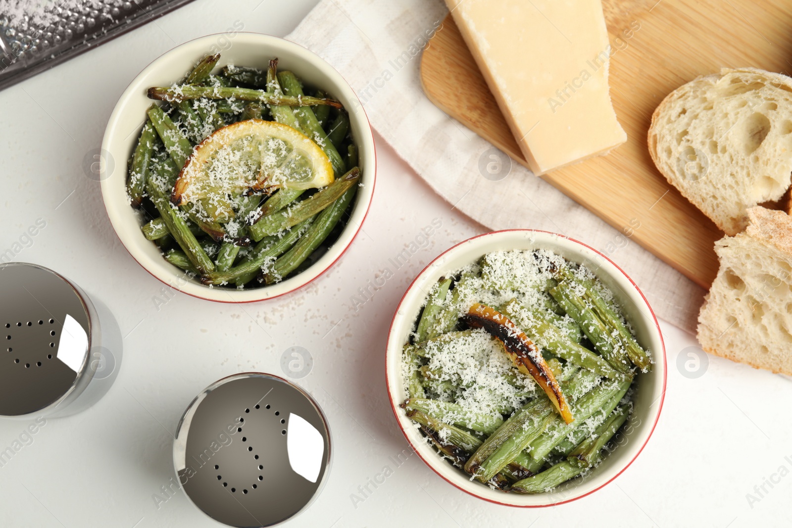 Photo of Delicious baked green beans served on white table, flat lay