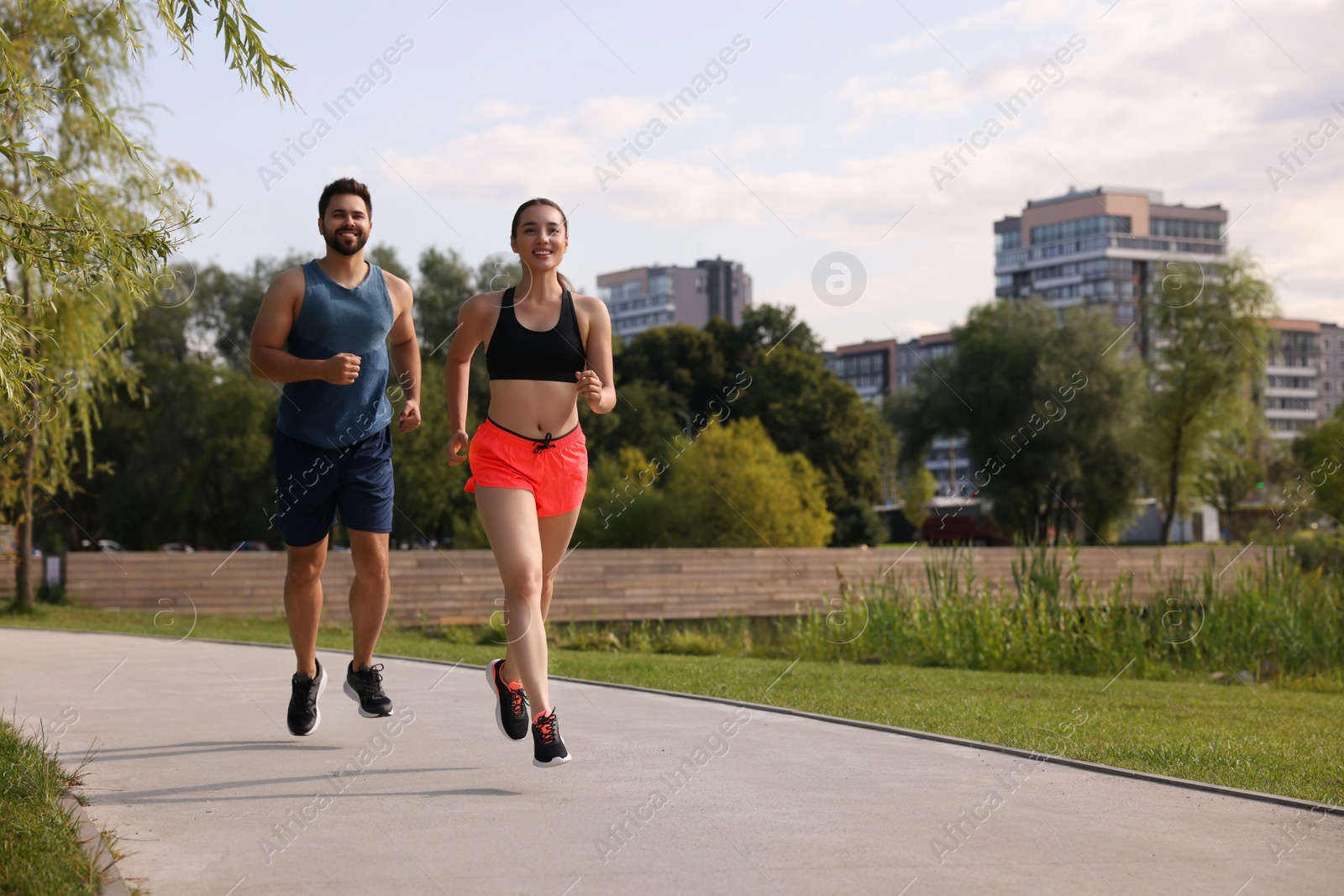 Photo of Healthy lifestyle. Happy couple running outdoors, space for text