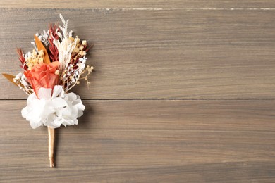 Beautiful boutonniere on wooden background, top view. Space for text