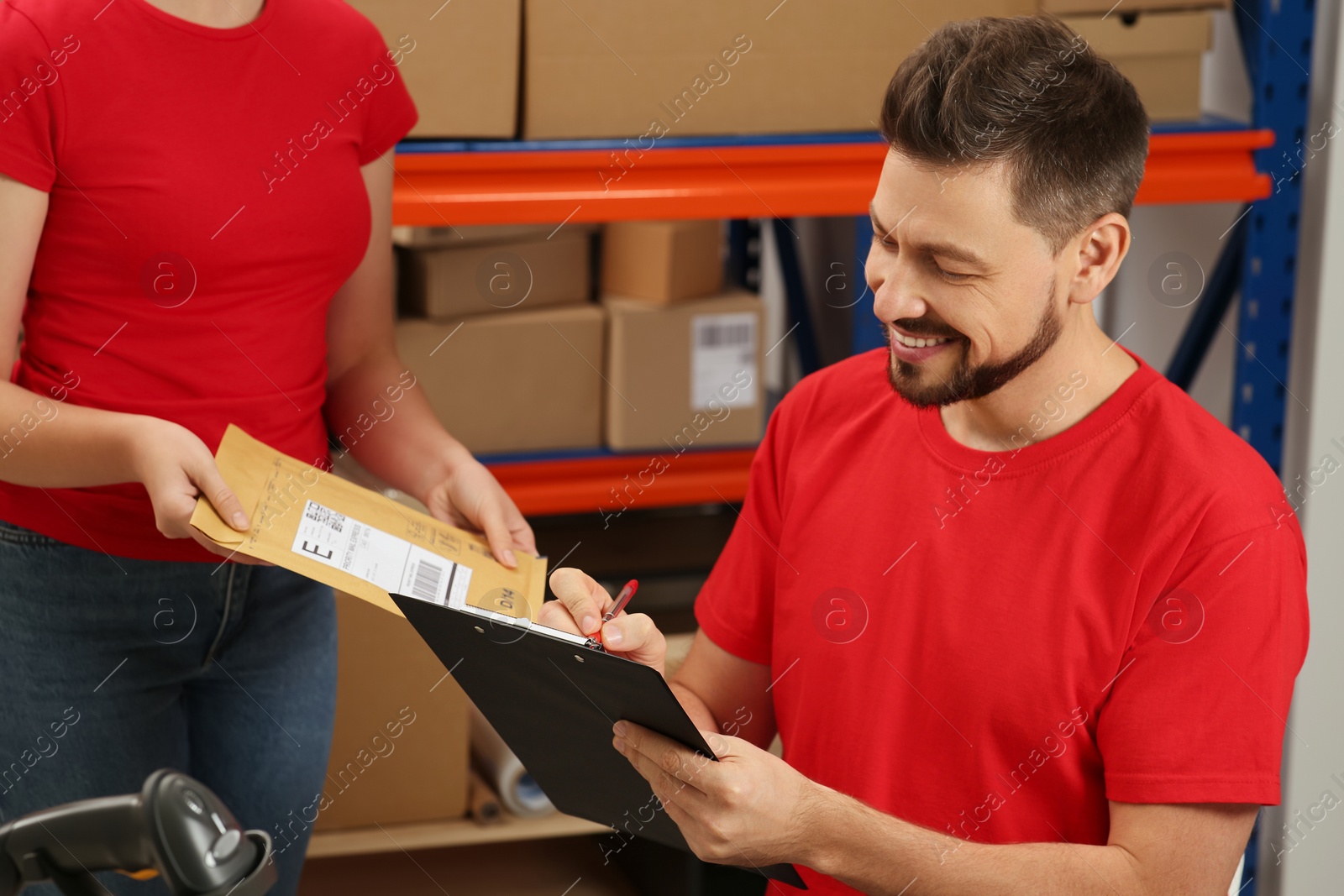 Photo of Post office workers checking parcel barcode indoors