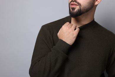 Photo of Man in stylish sweater on grey background, closeup. Space for text