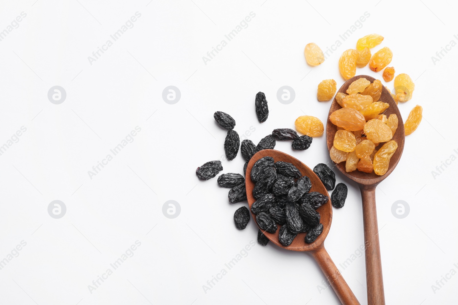Photo of Spoons with raisins and space for text on white background, top view. Dried fruit as healthy snack