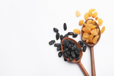 Photo of Spoons with raisins and space for text on white background, top view. Dried fruit as healthy snack