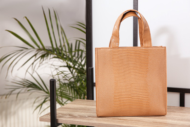 Photo of Leather woman's bag on wooden shelf in store