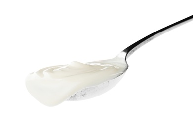 Photo of Metal spoon with sour cream on white background