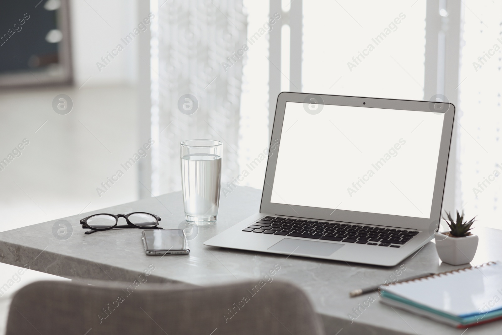 Photo of Modern workplace with laptop on grey table in office. Space for text