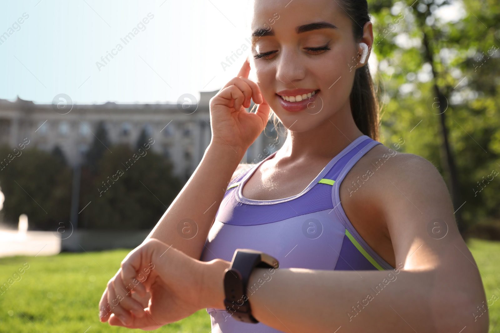 Photo of Woman checking fitness tracker after training in park, closeup