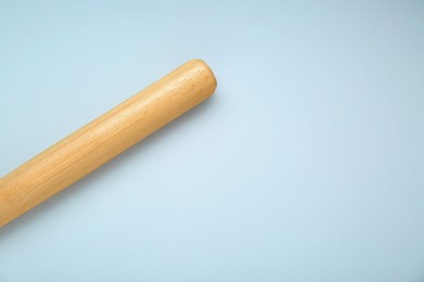 Photo of Wooden baseball bat on light grey background, top view. Space for text