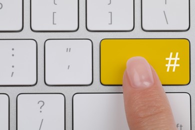 Image of Woman pressing yellow button with hashtag sign, top view