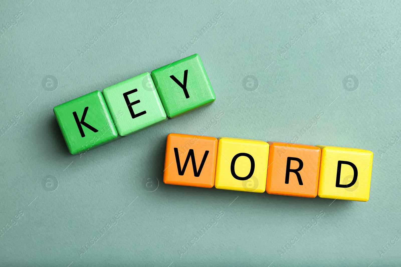 Photo of Colorful cubes with word KEYWORD on light green background, flat lay