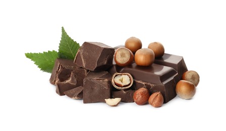 Delicious chocolate chunks with hazelnuts and green leaves on white background