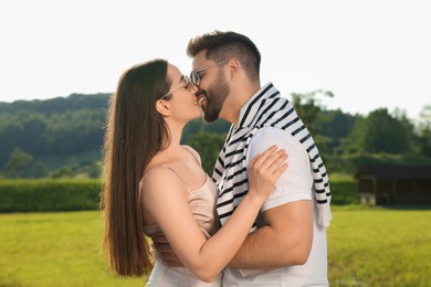 Photo of Romantic date. Beautiful couple kissing in park on sunny day