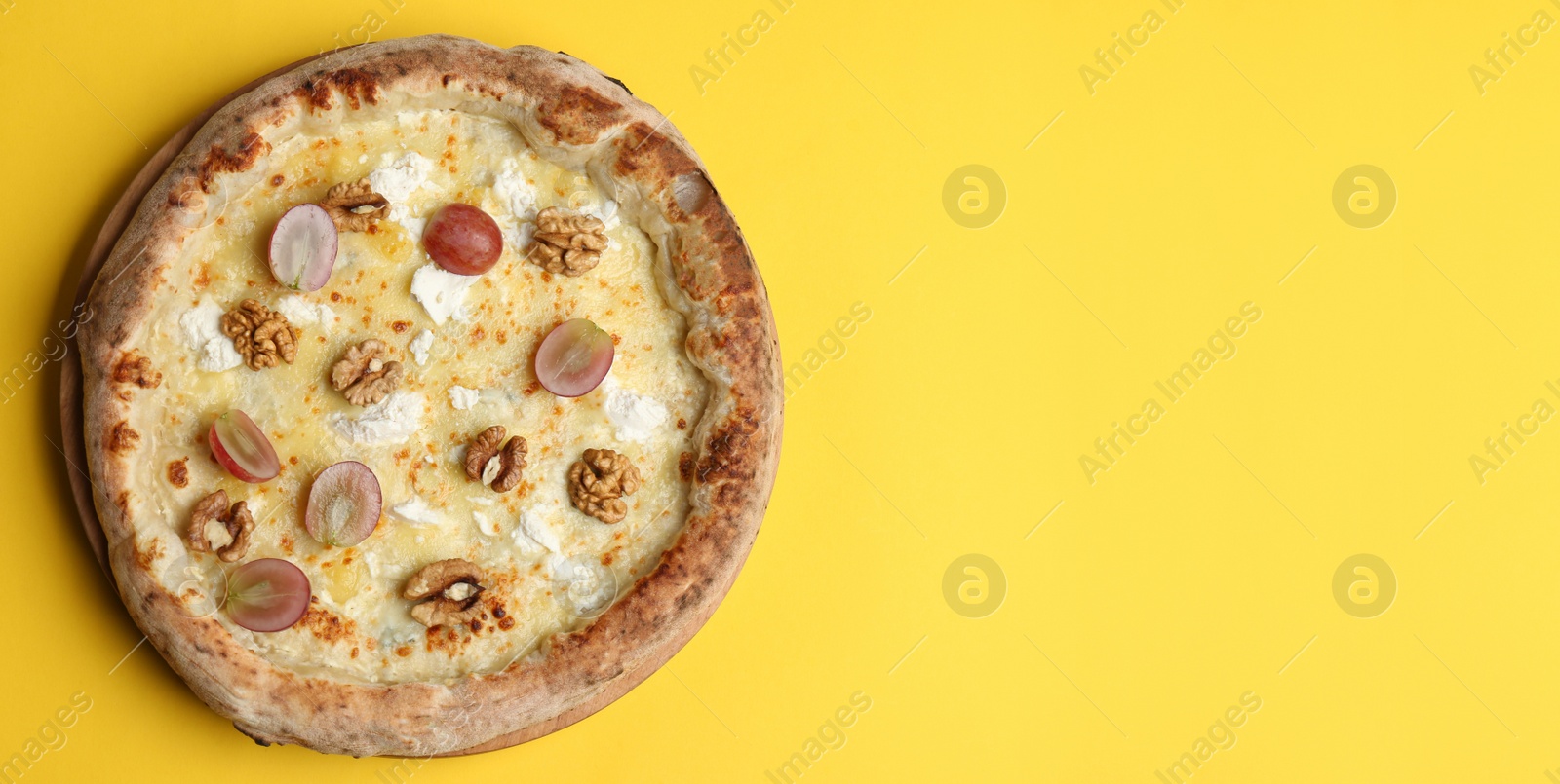 Image of Top view of hot delicious pizza on yellow background, space for text. Banner design 