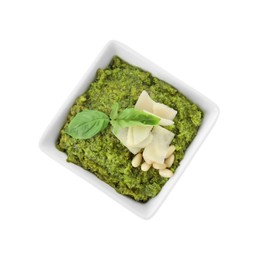 Photo of Bowl with delicious pesto sauce, cheese, pine nuts and basil leaves isolated on white, top view