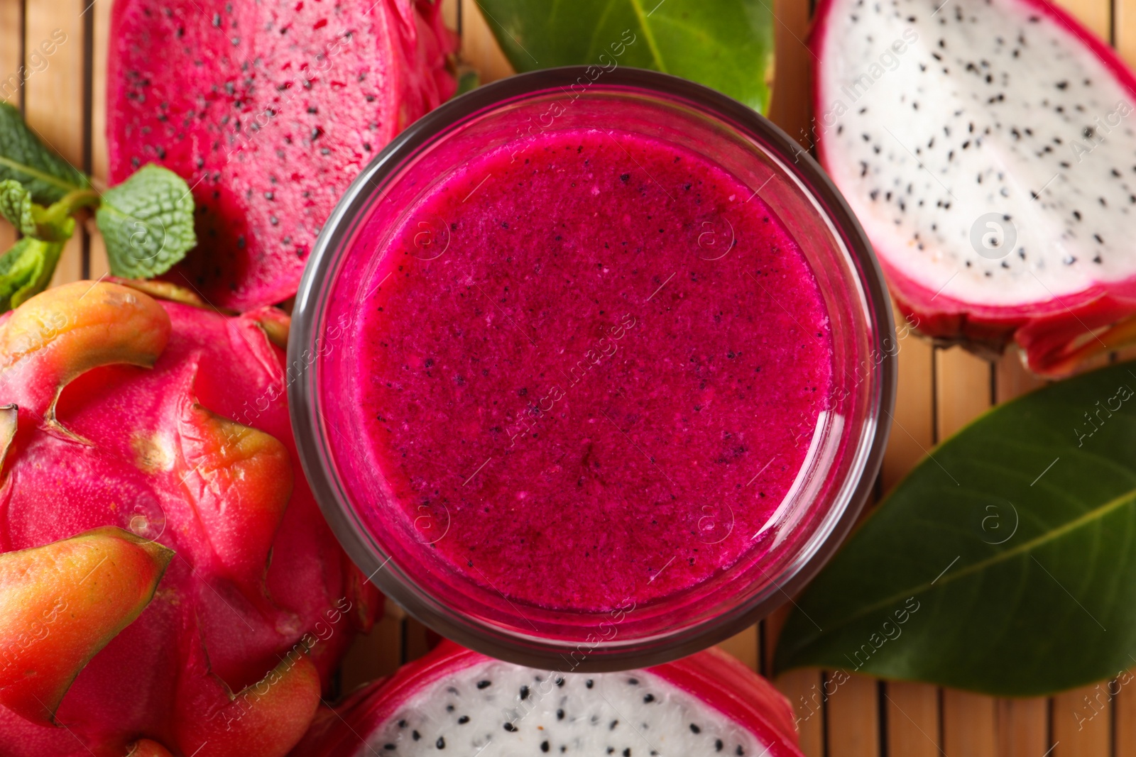 Photo of Delicious pitahaya smoothie and fresh fruits on table, flat lay