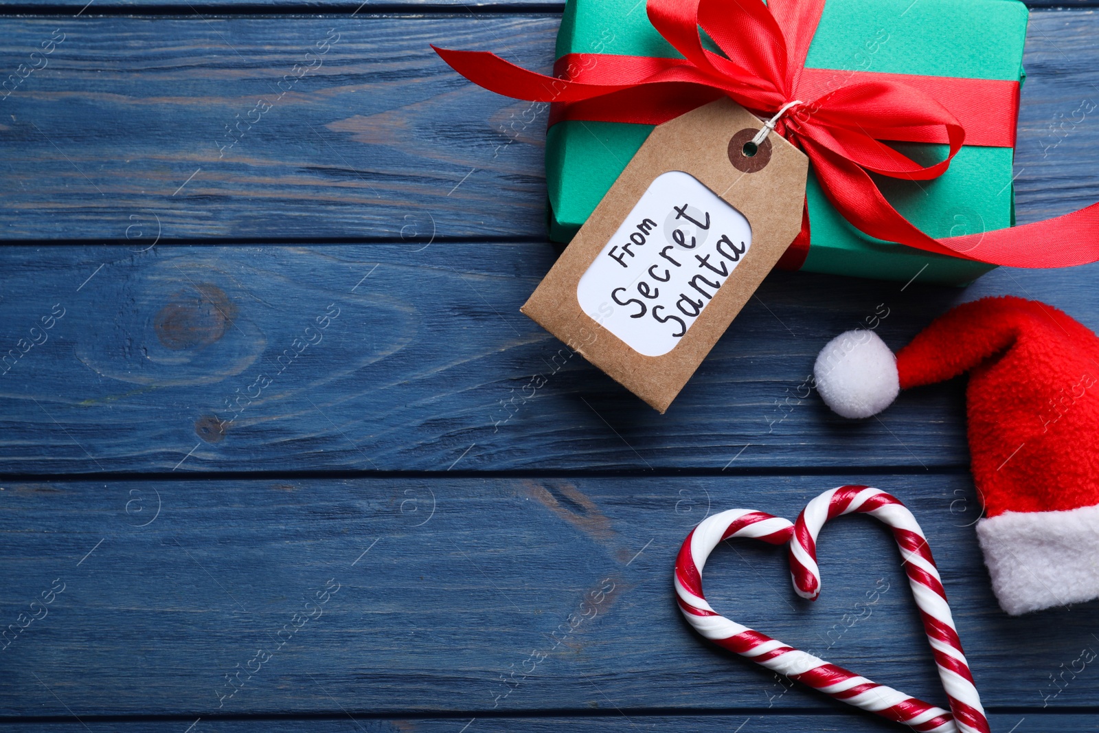 Photo of Flat lay composition with present from secret Santa on blue wooden background, space for text