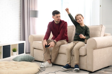Father and son playing video games at home