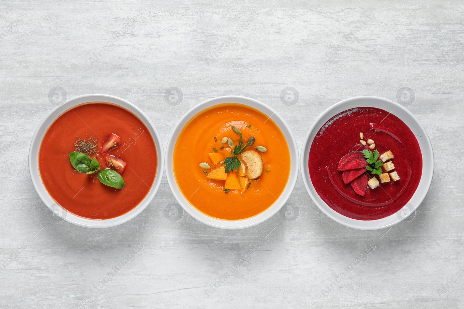 Photo of Various soups in bowls on white background, top view. Healthy food