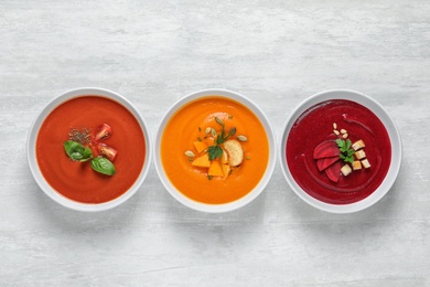 Various soups in bowls on white background, top view. Healthy food