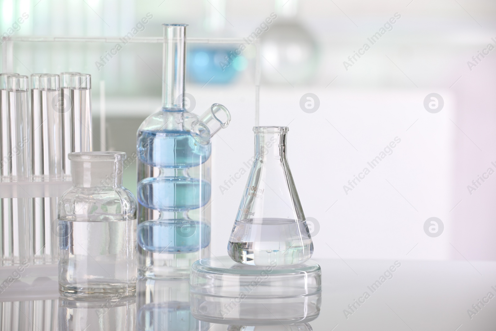Photo of Laboratory analysis. Different glassware with liquid on white table indoors. Space for text