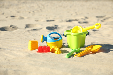 Different child plastic toys on sandy beach