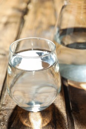 Photo of Glass of water on wooden table, closeup. Refreshing drink